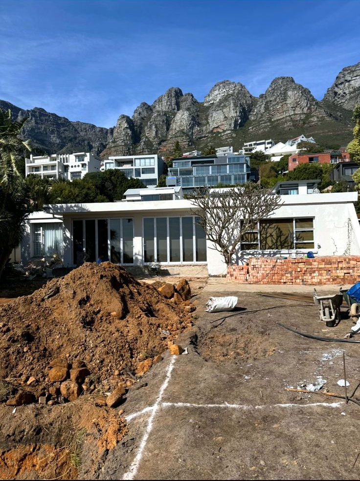 Excavated garden site with bare red earth in front of the house before landscaping