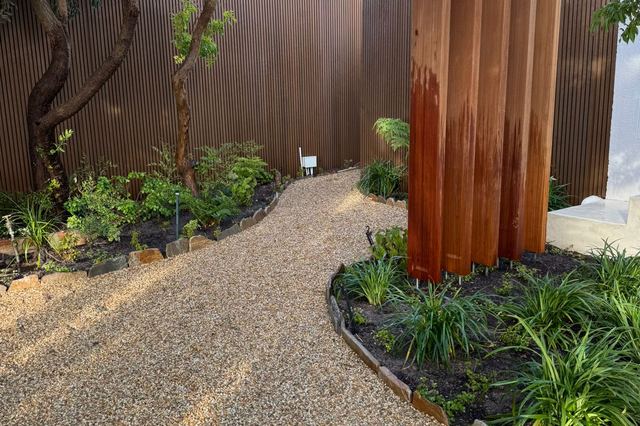Immaculate gravel path with crisp planting beds and corten steel edging